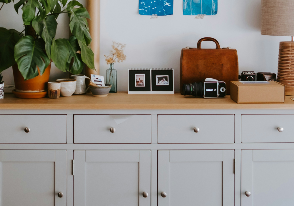 A white cabinet with decorations on top of it.