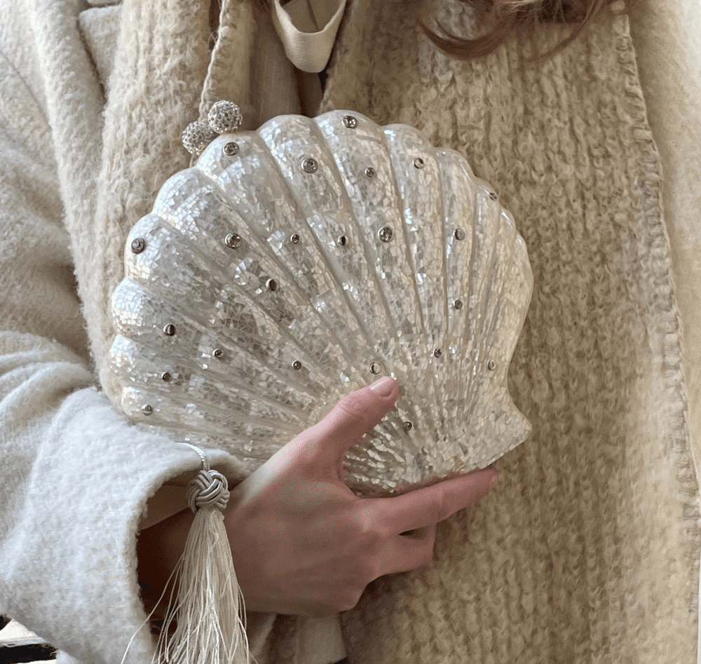 Woman holding a seashell vase.
