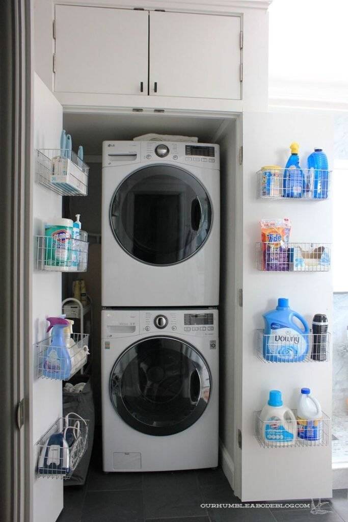 Wire storage baskets on laundry closet double doors, two washing machines placed on top of each other.