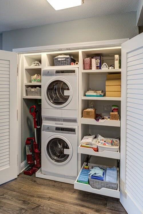 Custom-made laundry closet with different compartment shelves and sliding drawers.