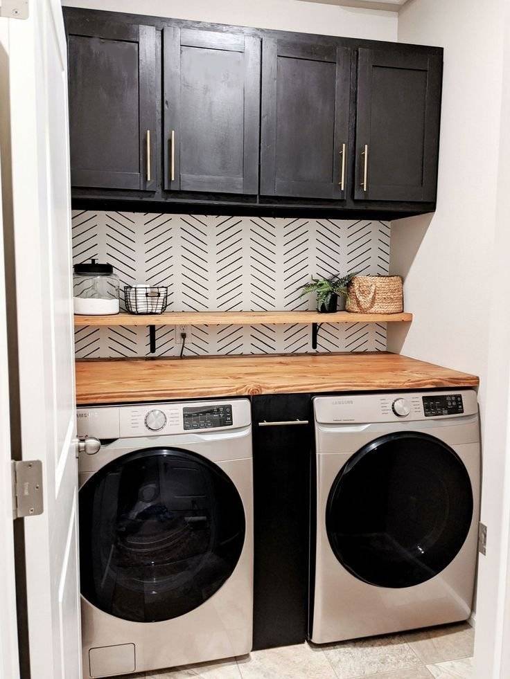 Black and white laundry closet with wooden touches.