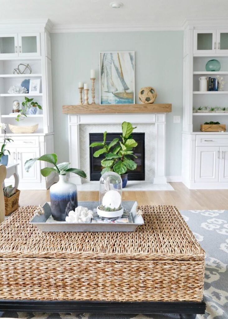 A beach house living room with coastal items and a woven coffee table.