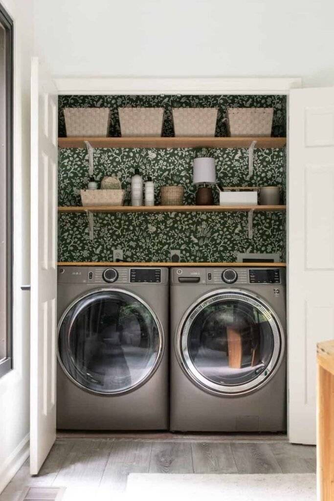 Laundry closet with green and white wallpaper.