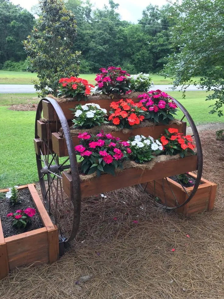 Wagon wheels used as a shelf and filled with flowers.