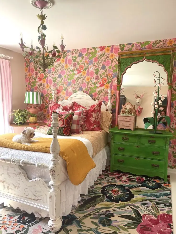 A whimsical bedroom with complex floral patterns and a green cabinet.