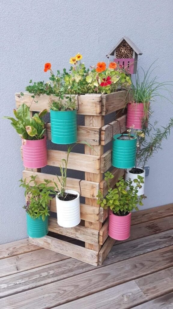 A vertical wooden crate with plant pots hanged on it.