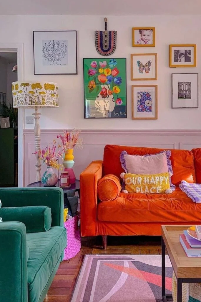 A colorful living room with a gallery wall, an orange sofa and a green sofa.