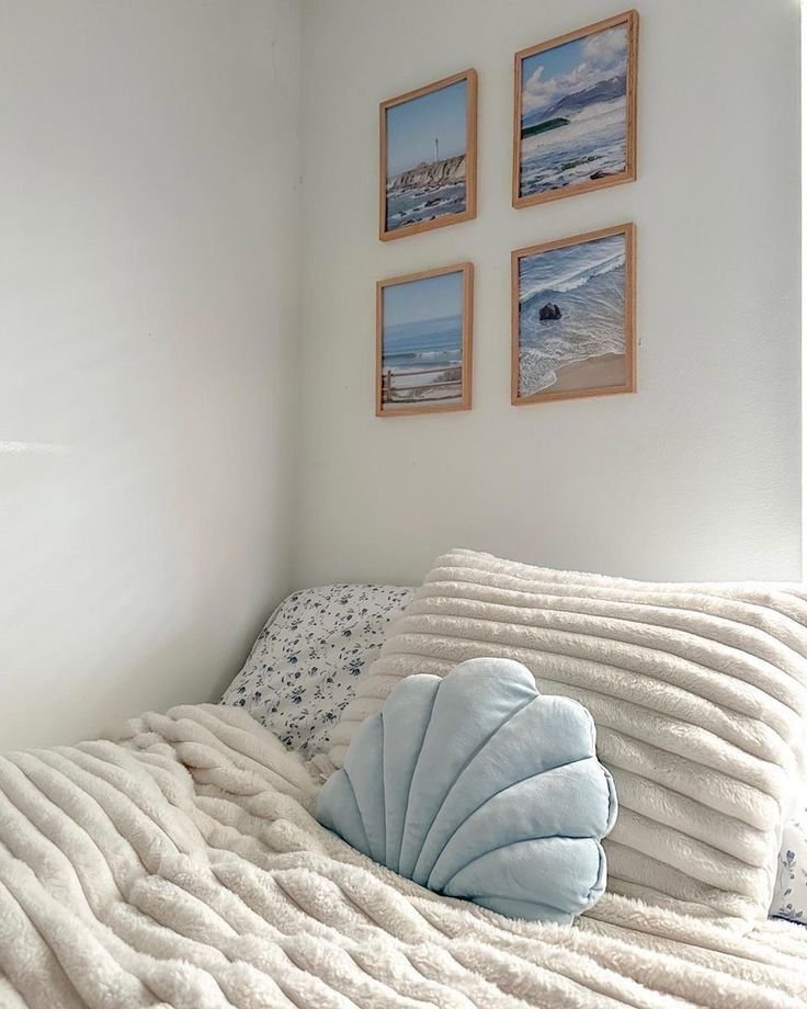 A seashell pillow on top of a bed.