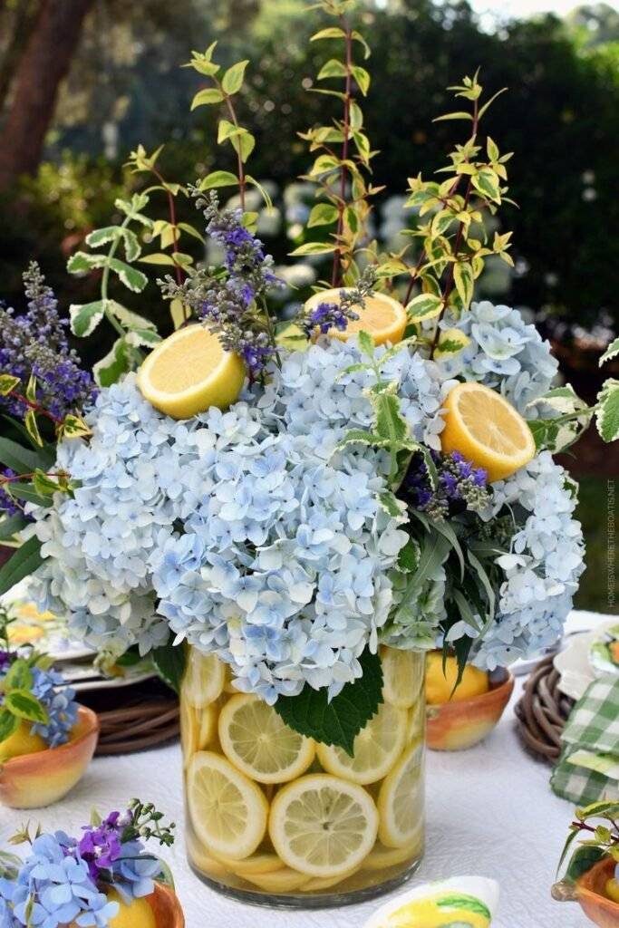 A lemon vase filled with hydrangeas.