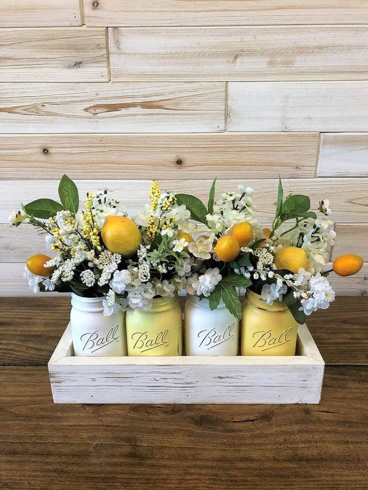 Jars filled with white flowers and lemons.