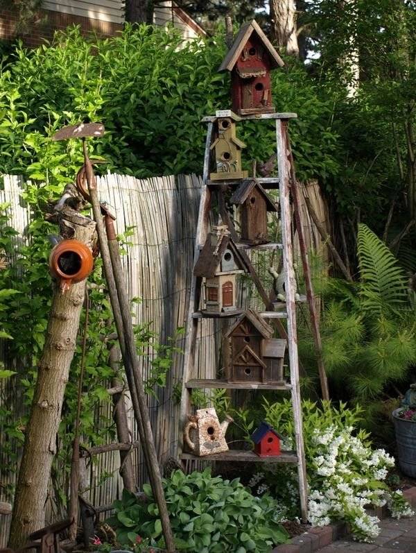 A wooden stepladder with birdhouses.