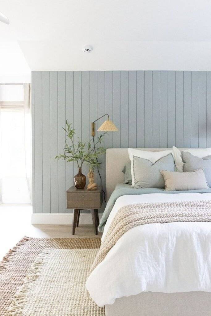 A light blue beadboard wall in a coastal chic bedroom.