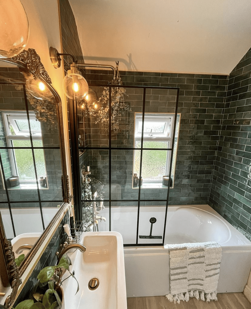 An antique gold mirror in a forest green bathroom.