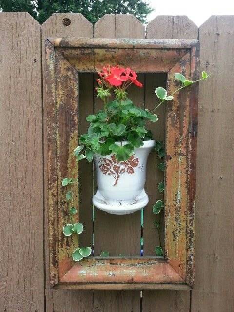 A window frame with a wall pocket planter.