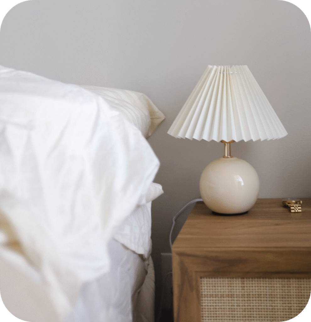 A white lamp on a nightstand.