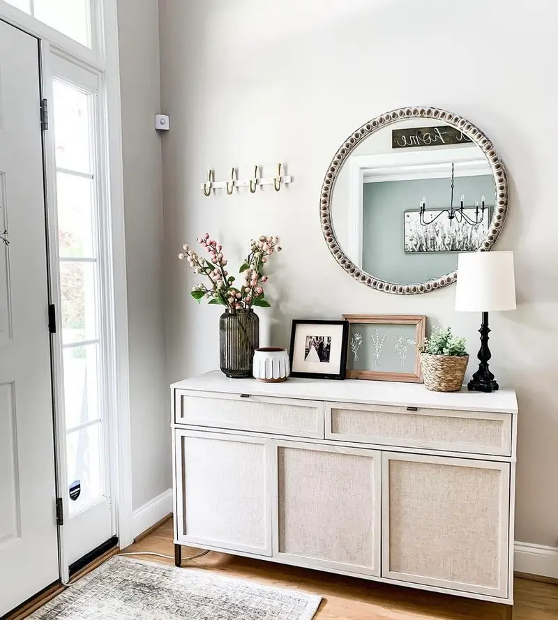 A gray mirror in a white and gray entryway.