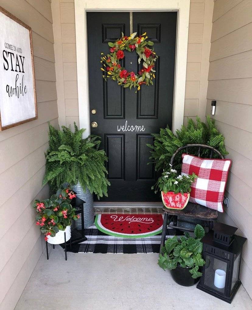 A black door with plants and watermelon items.