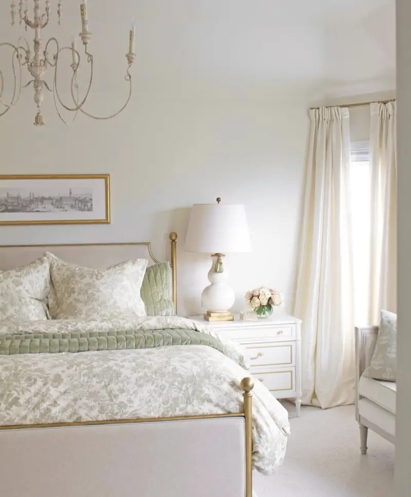 A white bedding with a green floral pattern in a luxurious and sophisticated bedroom.