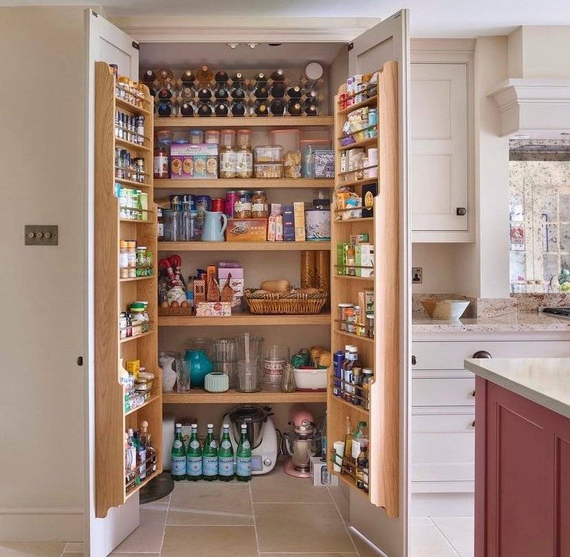 A neutral walk in pantry with wooden door racks.