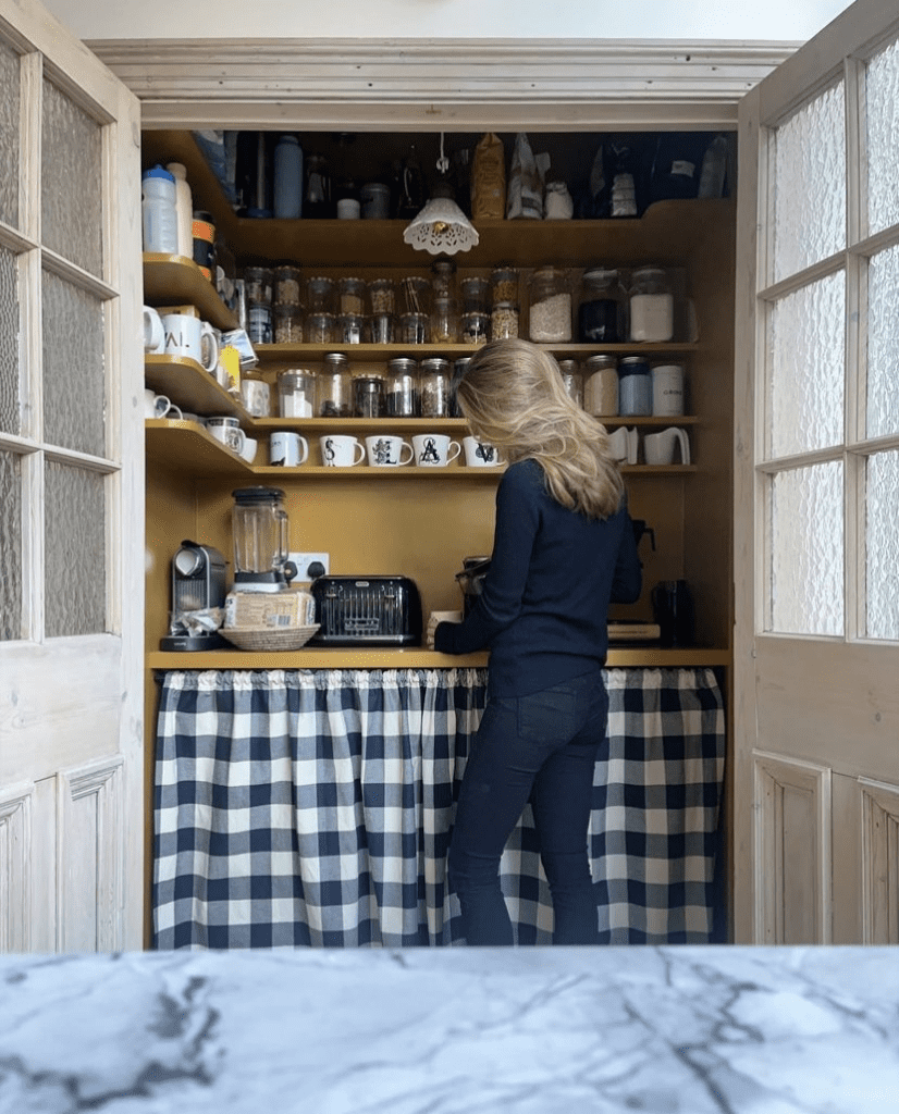 A woman in her vintage yellow walk in pantry.