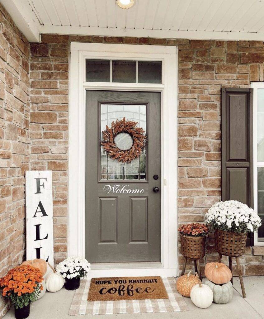 A fall porch with a fall garland and a fall sign.