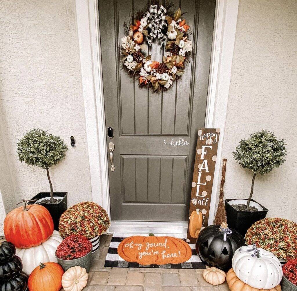 Pumpkins, a fall sign and a fall wreath.