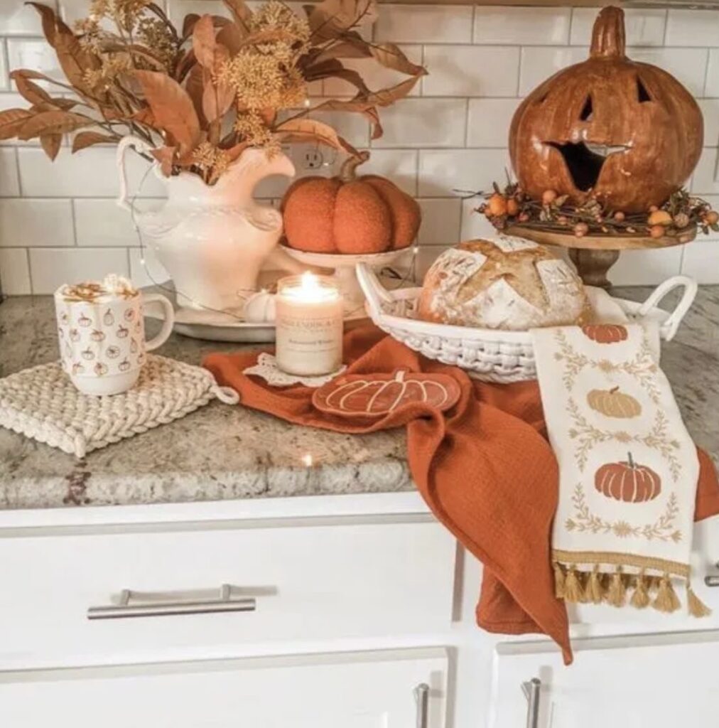 A ceramic pumpkin with fall stems on a kitchen countertop.