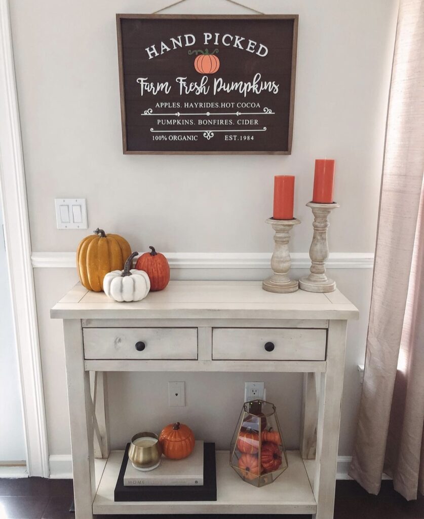 Pumpkins and candles on a table.