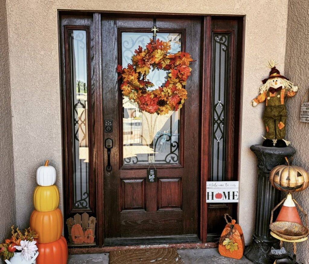 A wooden door with a maple leaf garland and figurines.