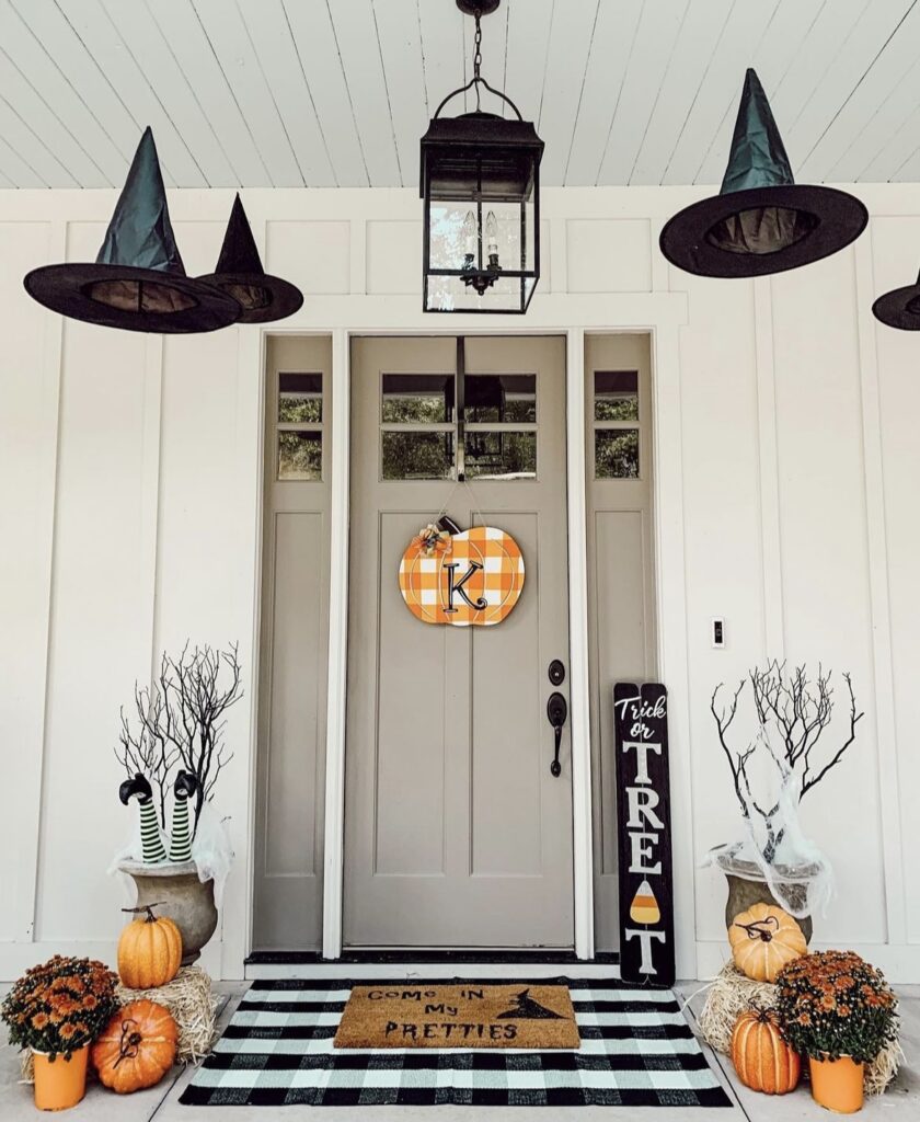 Witch hats with pumpkins on a porch.