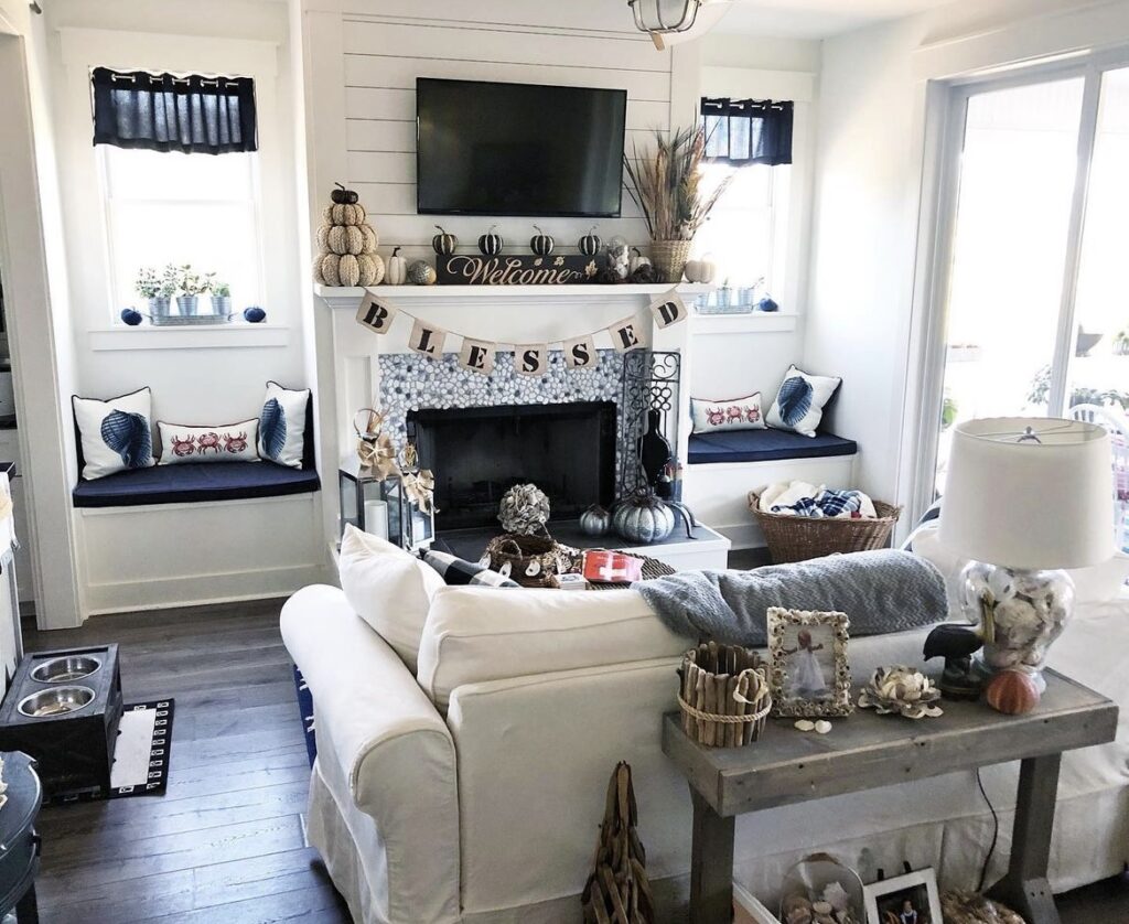 A black and gold living room with pumpkins and dried stems.