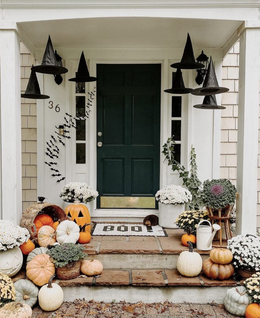 Witch hats and pumpkins on a Halloween porch.