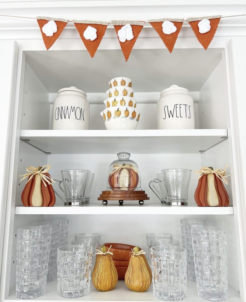 A pumpkin pie garland on top of a kitchen shelf.