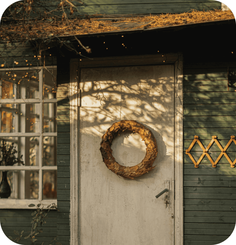 A maple leaf garland on a white front door.