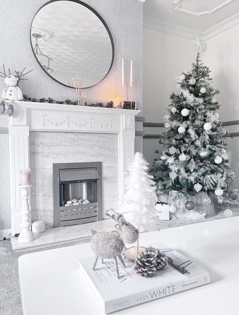 A white living room with a white Christmas tree.