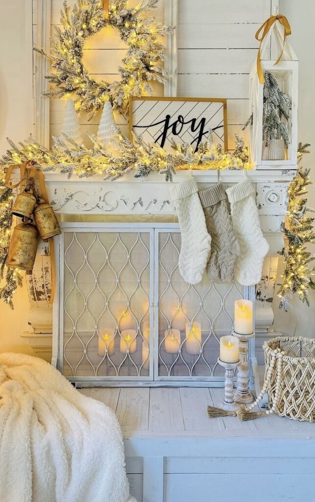 A mantel filled with pine branches, string lights and bells.