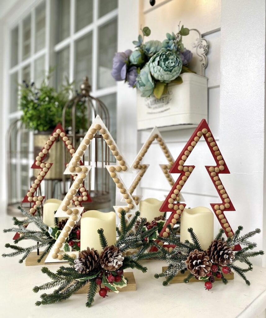 Candles decorated with pine branches, red berries and pine cones.