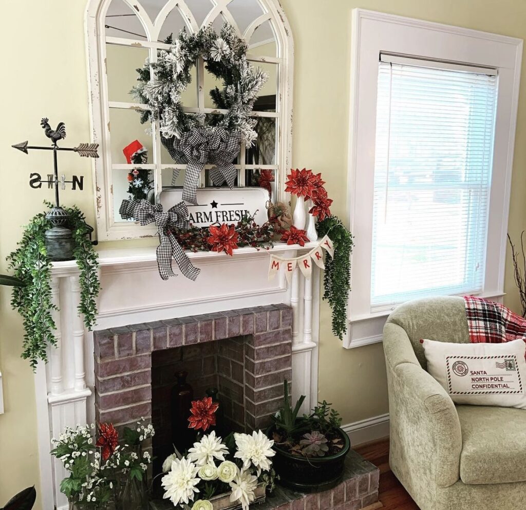 A mantel with red poinsettias, red berries and buffalo plaid bows.