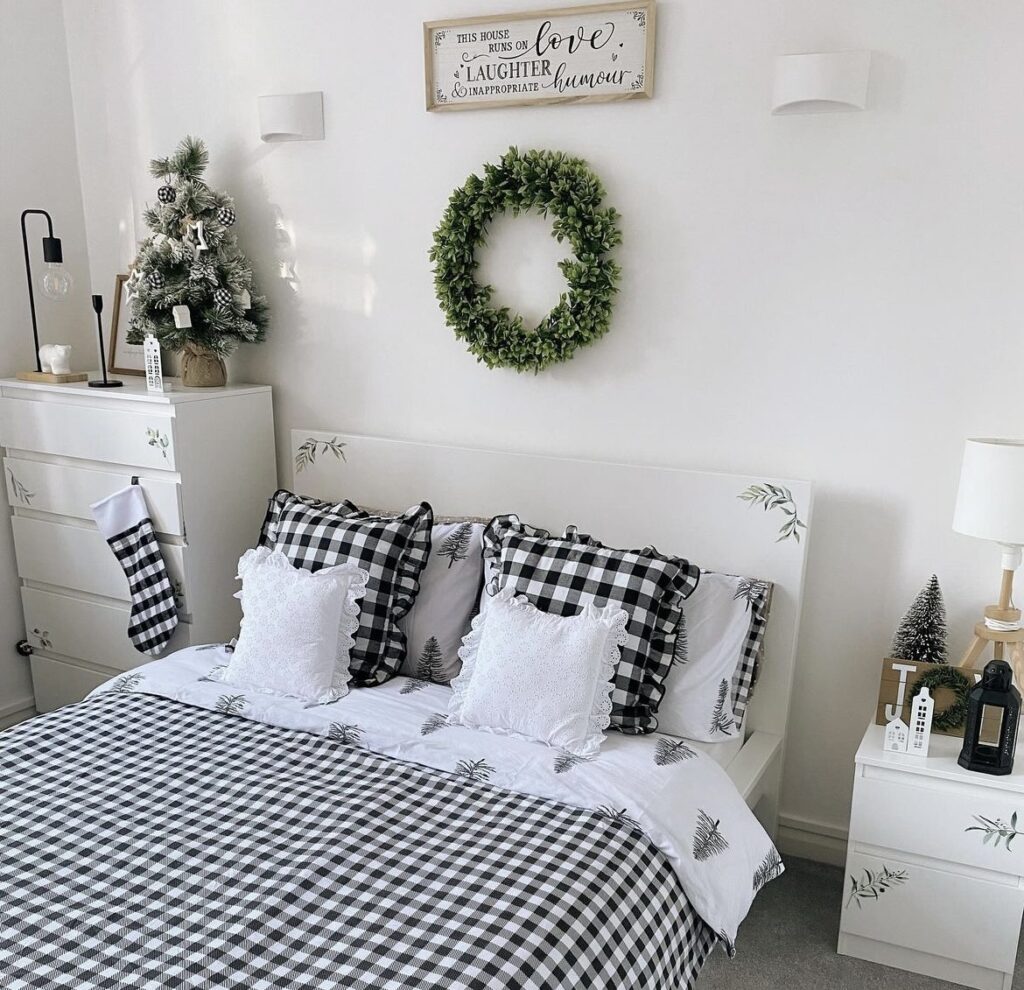 A Christmas wreath above a bed.