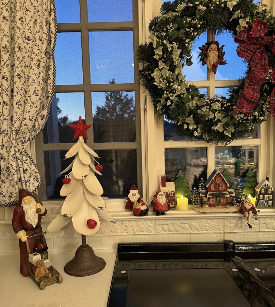 A Christmas village on a window sill.