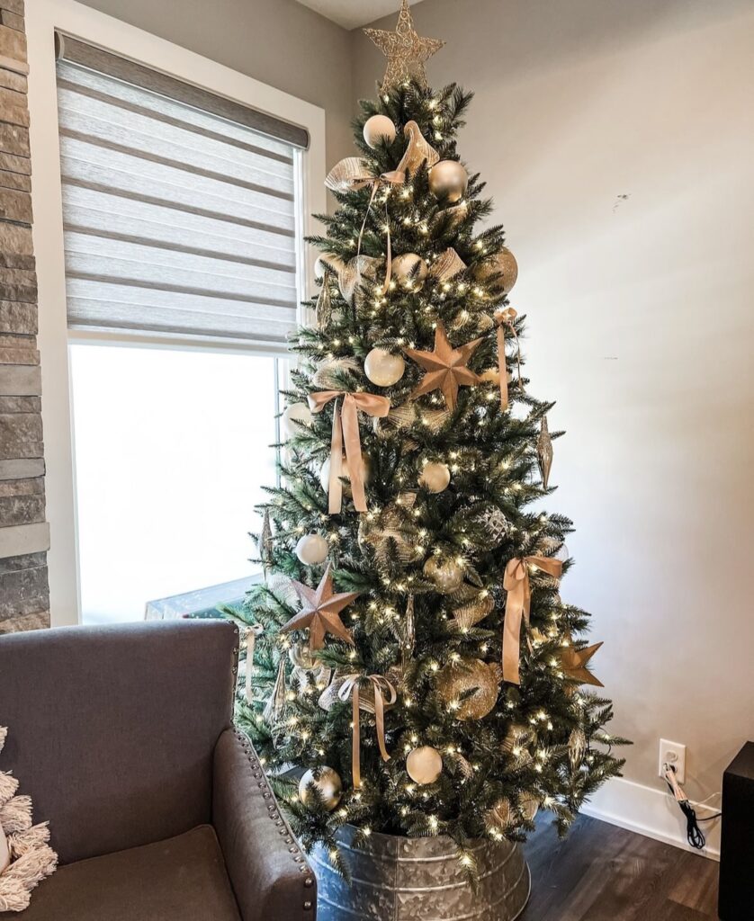 A neutral Christmas tree with copper ribbon bows and stars.