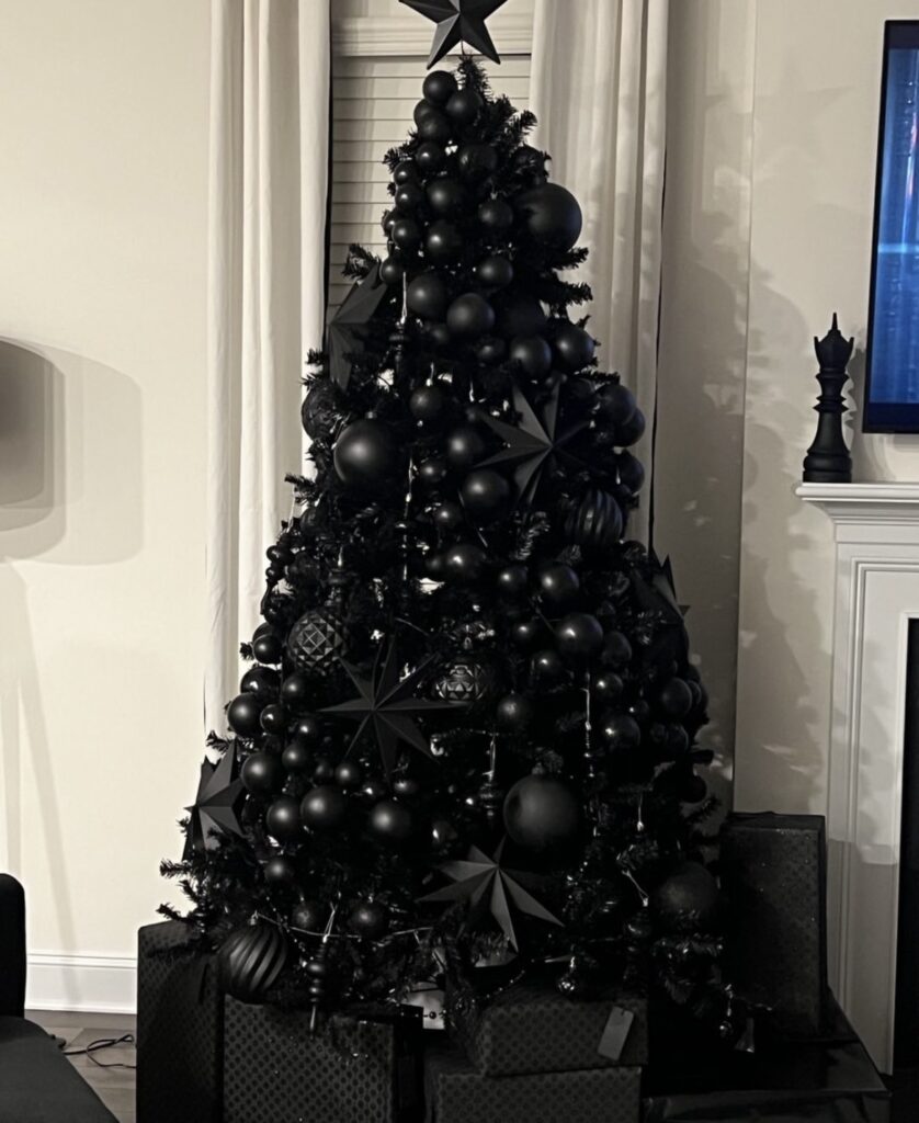 A black Christmas tree with stars and finial ornaments.