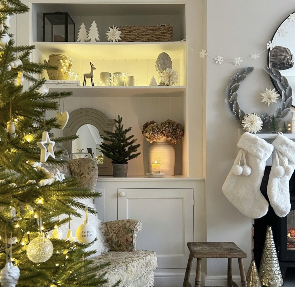 A shelf filled with white Christmas decorations.