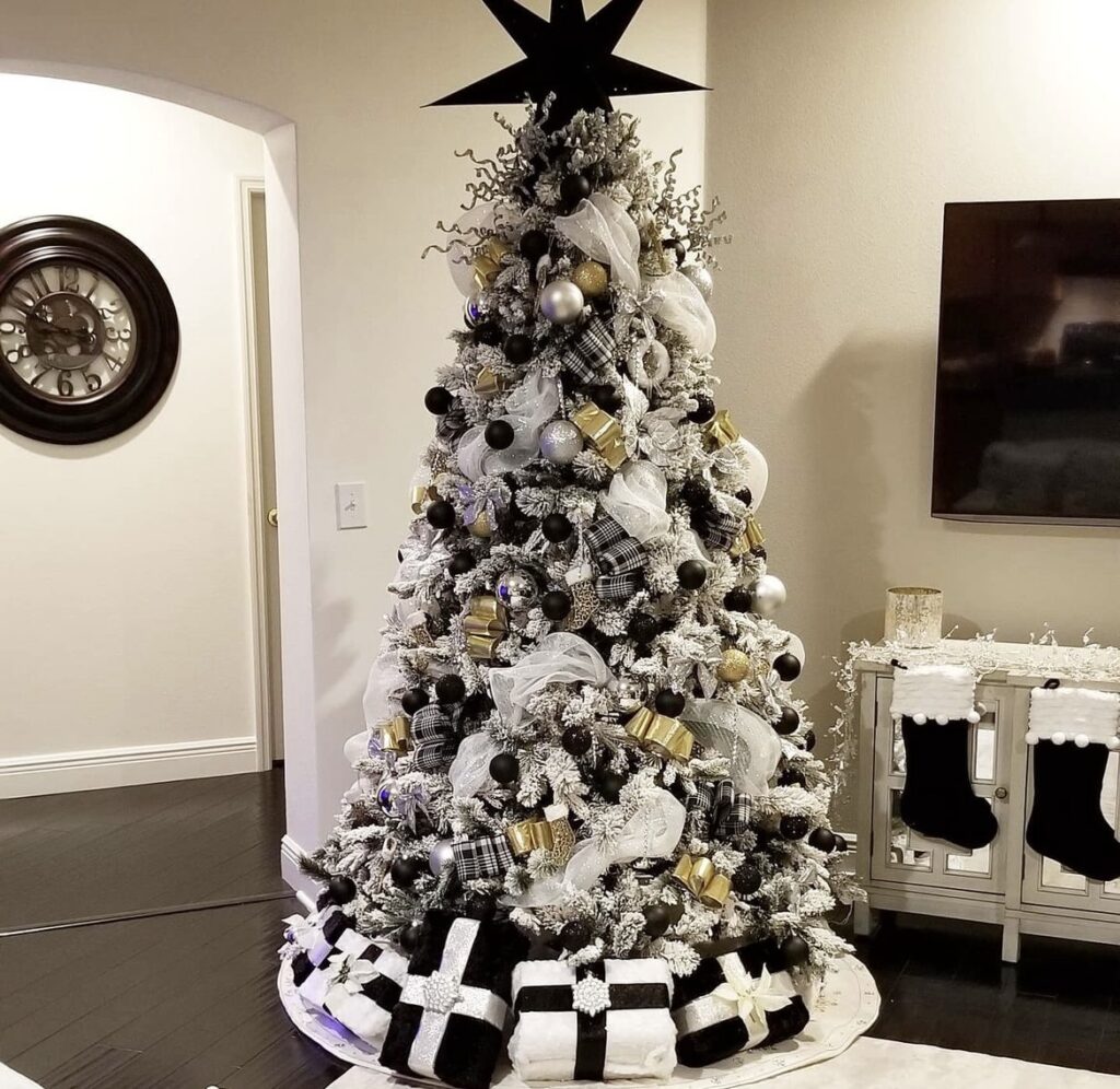 A black and white Christmas tree with black and white buffalo bows and gold balls.