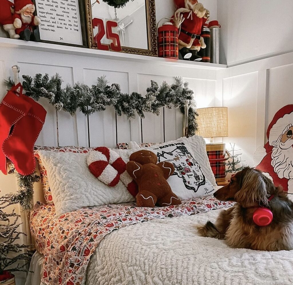 A pine branch garland with red Christmas stockings on the headboard.