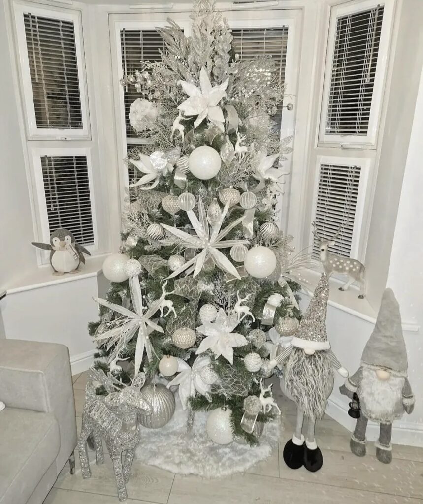 A silver Christmas tree with white flowers and silver stems.