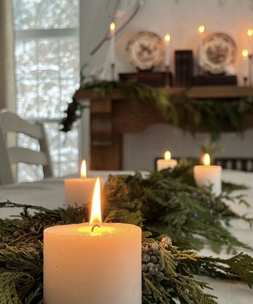 A Christmas centerpiece with pine branches and candles.