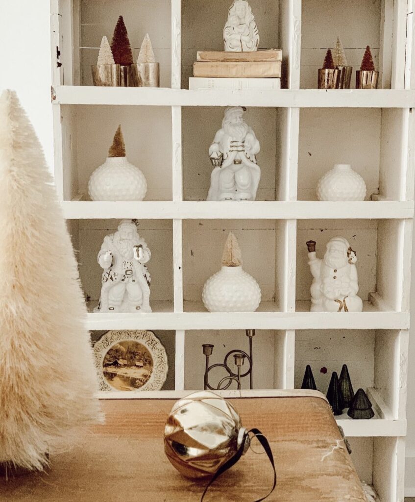 A shelf fillled with white Santa Claus.