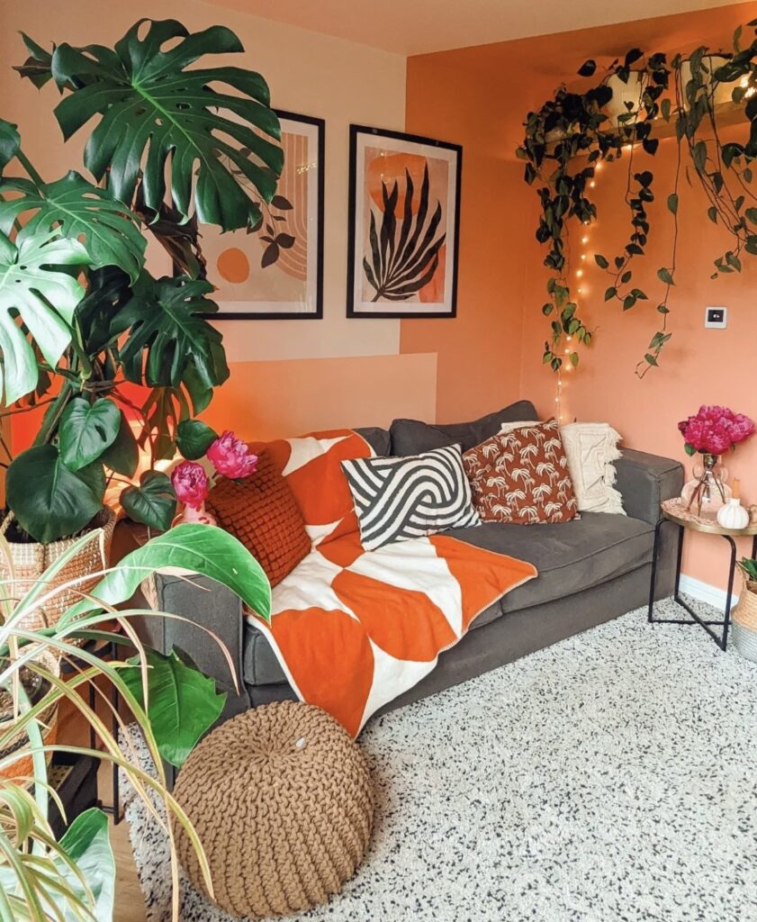 Orange minimalist leaf prints above the sofa.