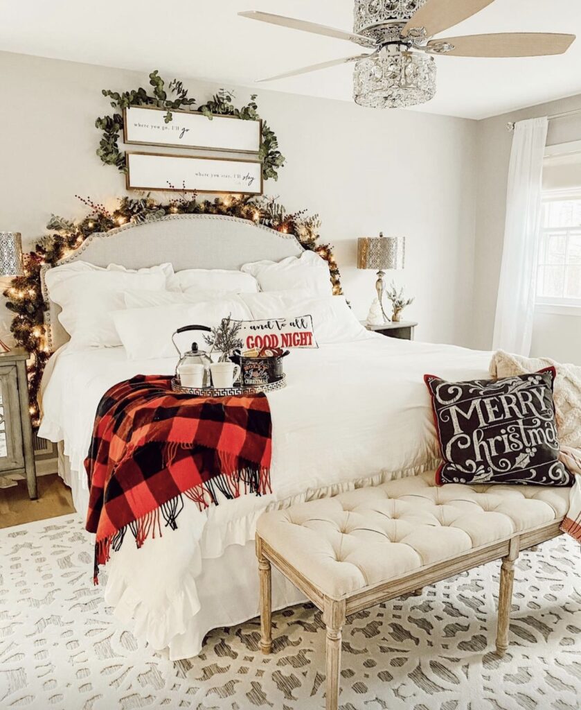 A bed with a pine branch garland on the headboard and on the framed quote.